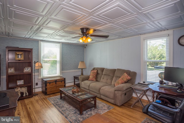 living room with light hardwood / wood-style flooring, ceiling fan, and baseboard heating