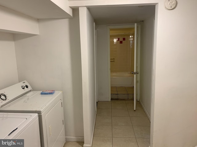 laundry room with washing machine and dryer and light tile floors