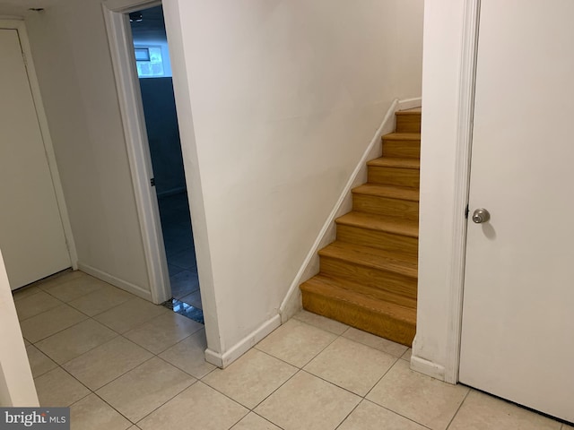 staircase featuring light tile floors