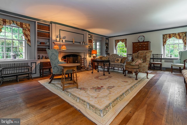 living room with dark hardwood / wood-style flooring, ornamental molding, and plenty of natural light