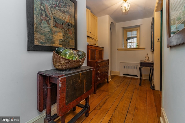 corridor featuring radiator heating unit and hardwood / wood-style floors