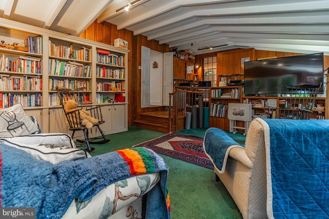 sitting room featuring wooden walls, dark colored carpet, and lofted ceiling with beams