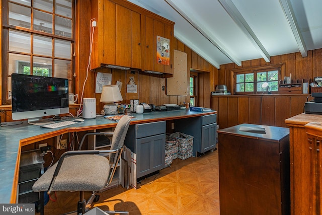 office featuring light parquet flooring, wooden walls, and vaulted ceiling with beams