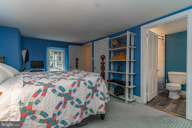 bedroom featuring connected bathroom and hardwood / wood-style floors