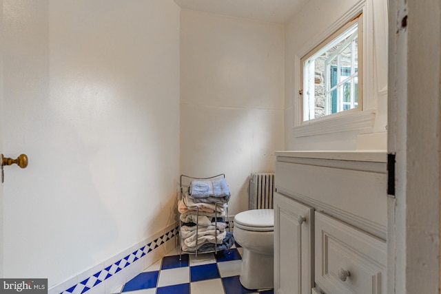 bathroom featuring vanity, tile floors, radiator heating unit, and toilet