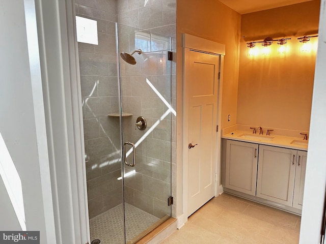 bathroom with tile patterned floors, a shower with door, and vanity