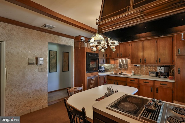 kitchen with a chandelier, premium range hood, sink, backsplash, and black oven