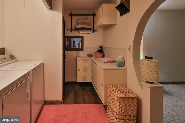 laundry area with dark carpet, washing machine and dryer, and cabinets