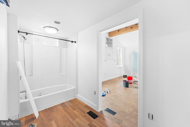 bathroom with wood-type flooring and tub / shower combination