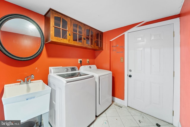 laundry room featuring washer and clothes dryer, sink, and light tile patterned floors