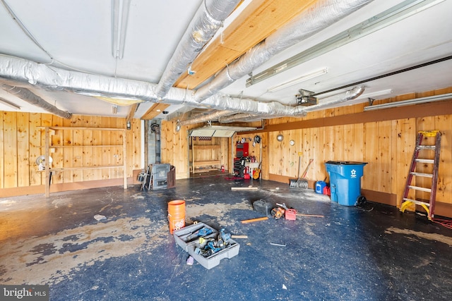 garage featuring a garage door opener and wooden walls