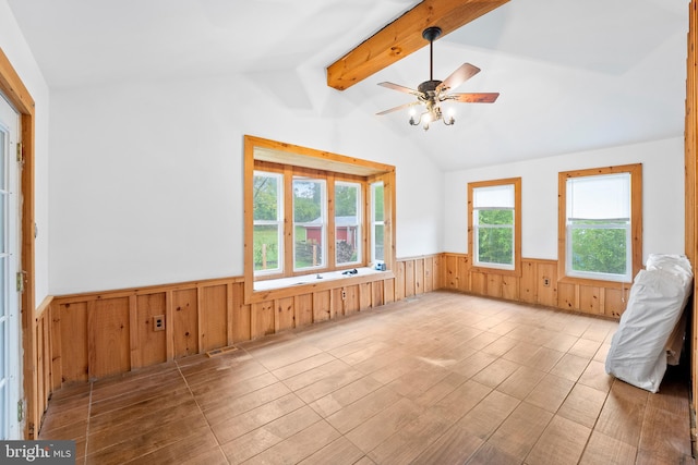 empty room featuring light wood-type flooring, vaulted ceiling with beams, wood walls, and ceiling fan