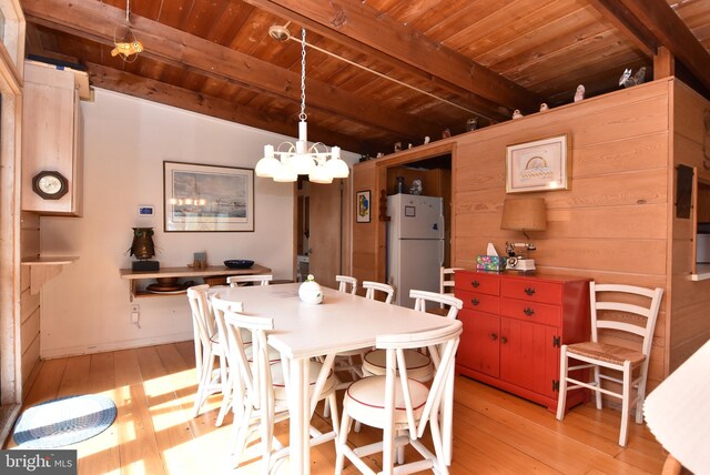 dining area with an inviting chandelier, light hardwood / wood-style floors, wood ceiling, and beamed ceiling