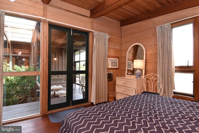 bedroom with an AC wall unit, dark wood-type flooring, access to exterior, wooden walls, and beam ceiling