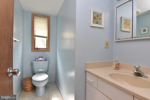 bathroom with toilet, tile floors, and vanity with extensive cabinet space