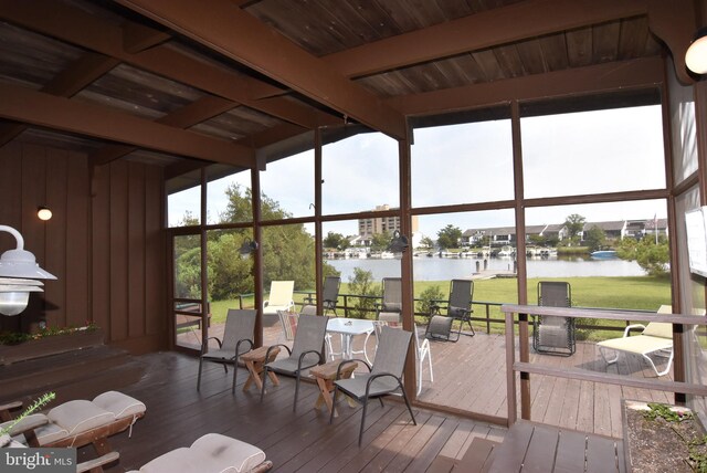 sunroom / solarium with a water view, wood ceiling, and beamed ceiling