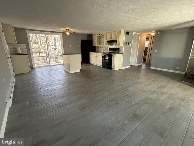 unfurnished living room featuring hardwood / wood-style flooring, ceiling fan, a textured ceiling, and sink