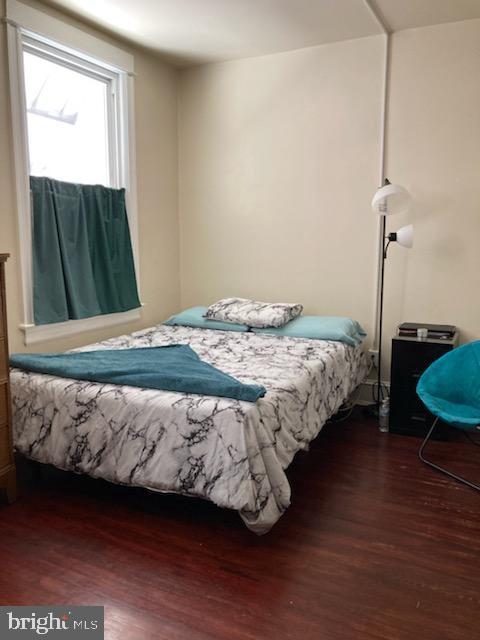 bedroom with dark hardwood / wood-style flooring