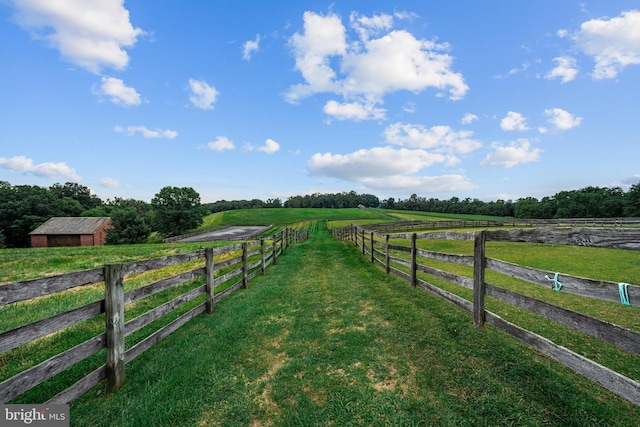 view of yard with a rural view and an outdoor structure