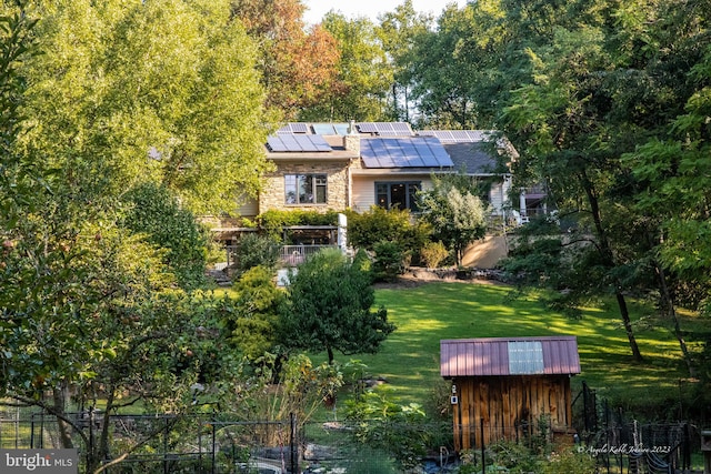 exterior space featuring a front lawn and solar panels