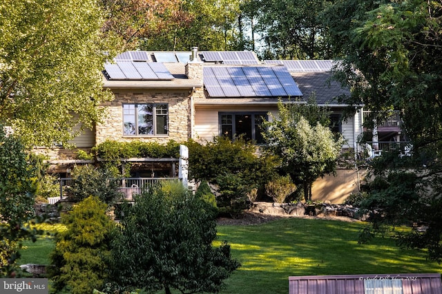 view of front of house with a front yard and solar panels