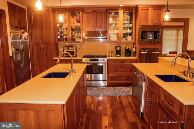 kitchen with a center island with sink, stainless steel appliances, decorative light fixtures, and exhaust hood