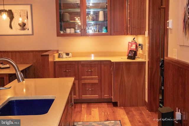 kitchen with light hardwood / wood-style flooring, hanging light fixtures, and sink