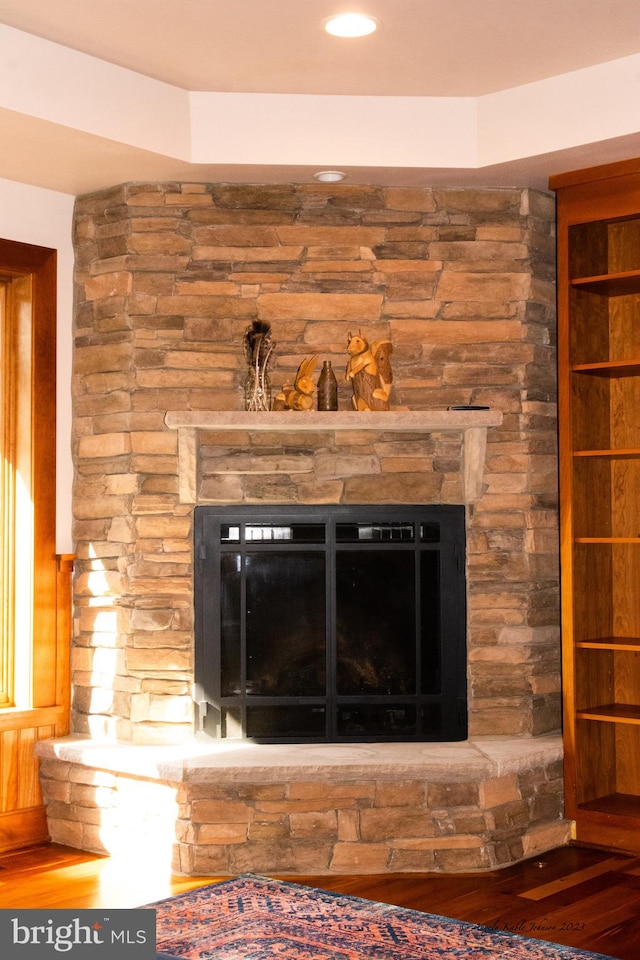 interior details with a stone fireplace and dark hardwood / wood-style flooring