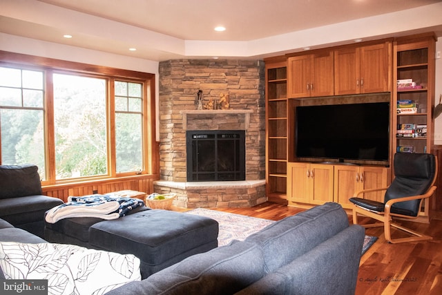 living room featuring dark hardwood / wood-style floors, a fireplace, and a wealth of natural light