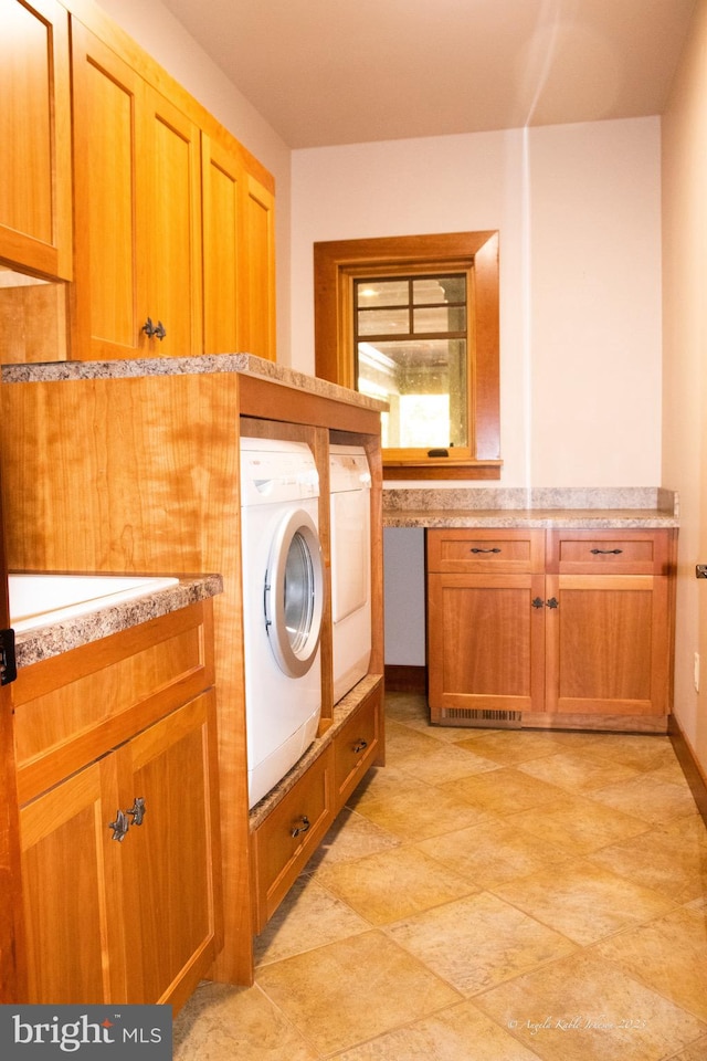 washroom with sink, light tile floors, and washer and dryer