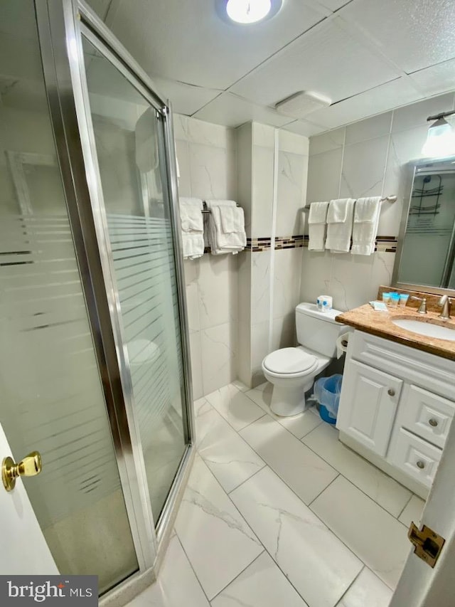 bathroom featuring vanity, tile floors, a shower with door, and toilet