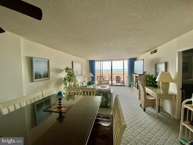 dining space with ceiling fan, a textured ceiling, and carpet