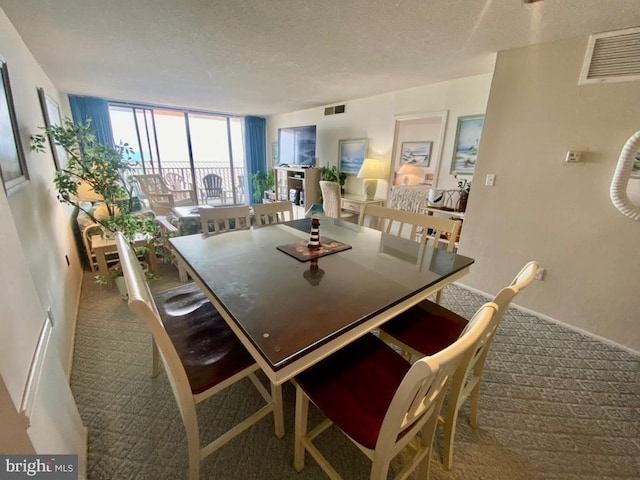 dining room featuring floor to ceiling windows, carpet floors, and a textured ceiling