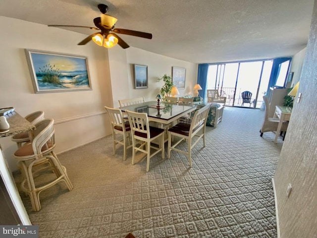 carpeted dining room featuring ceiling fan, floor to ceiling windows, and a textured ceiling