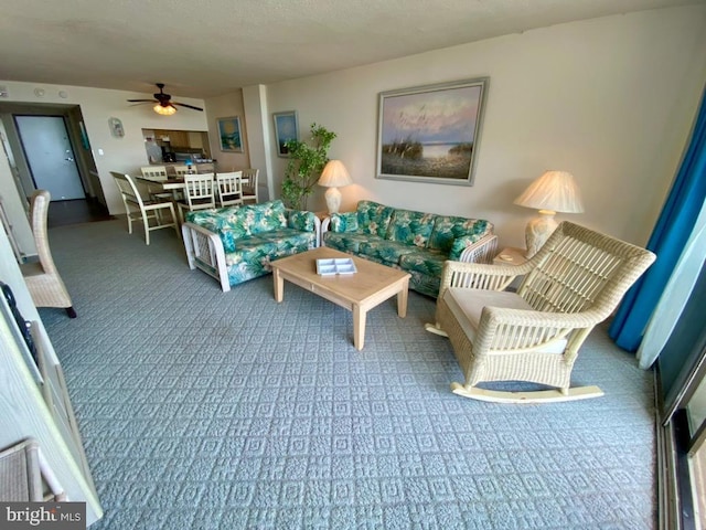 living room featuring dark carpet and ceiling fan