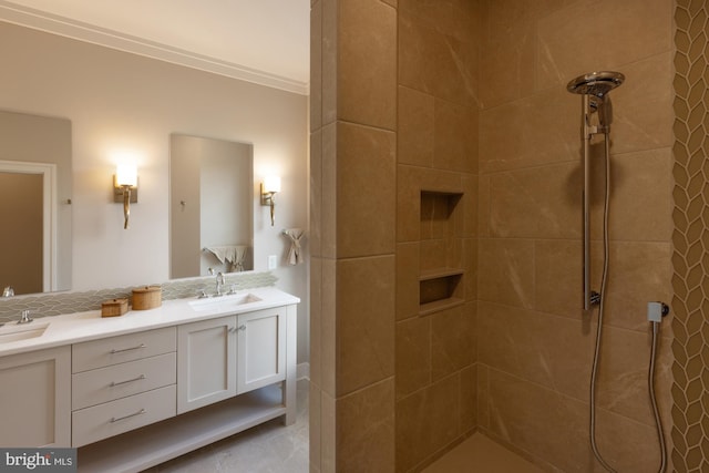 bathroom with crown molding, double vanity, a tile shower, and backsplash