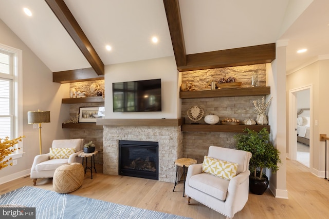 living room featuring lofted ceiling with beams, light hardwood / wood-style floors, and a fireplace