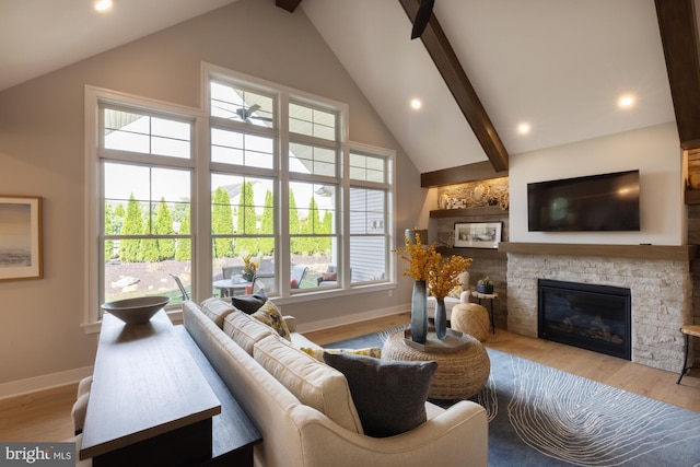 living room with a fireplace, light hardwood / wood-style flooring, beam ceiling, and high vaulted ceiling