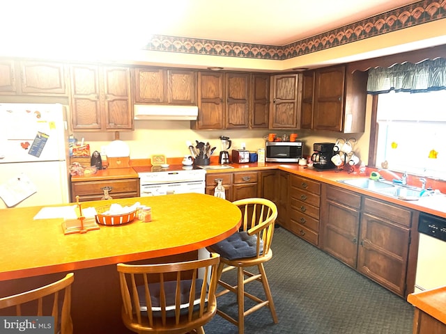 kitchen featuring dark colored carpet, white appliances, and sink