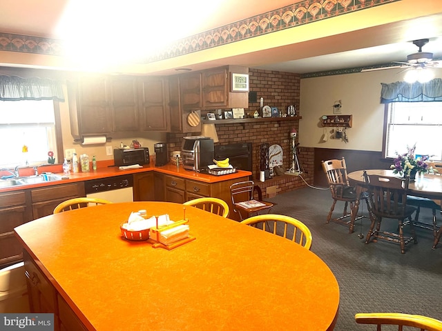 kitchen featuring a brick fireplace, ceiling fan, plenty of natural light, and dark carpet