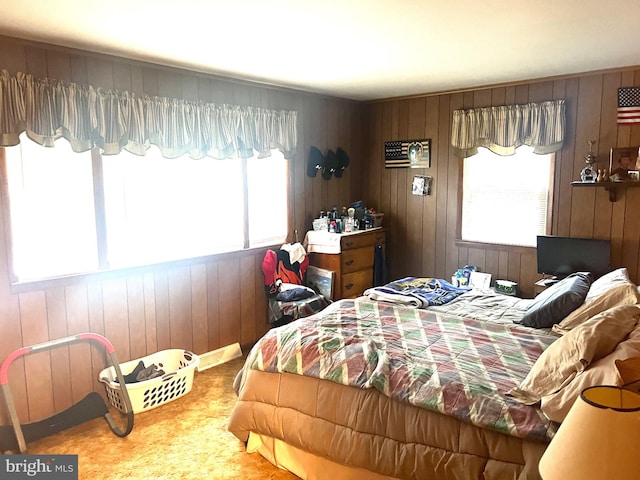 bedroom featuring wood walls and multiple windows