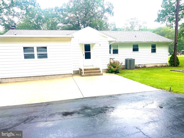 exterior space with central air condition unit and a yard