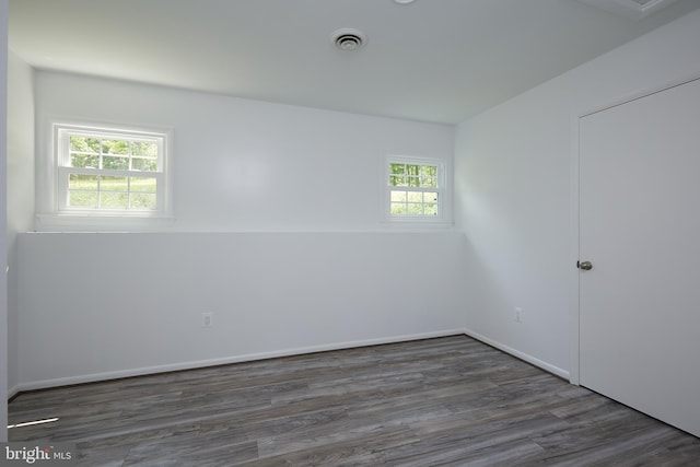 unfurnished room featuring dark wood-type flooring and a wealth of natural light