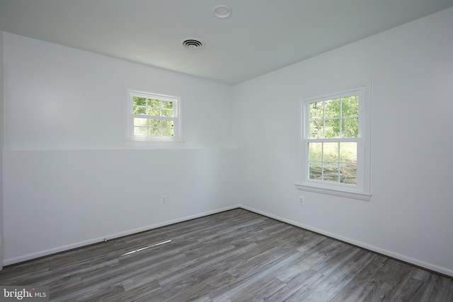 unfurnished room with dark hardwood / wood-style flooring and a wealth of natural light