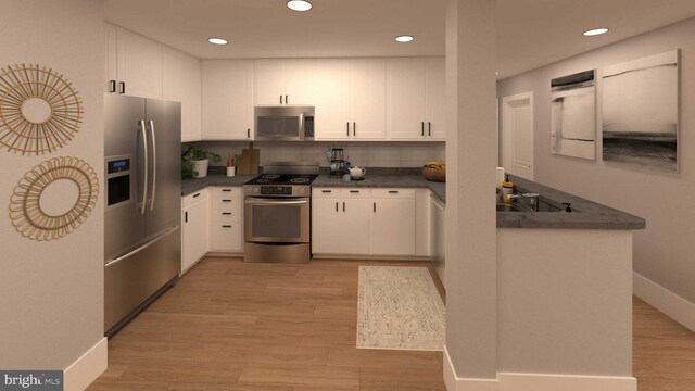 kitchen featuring stainless steel appliances, white cabinetry, and light hardwood / wood-style flooring