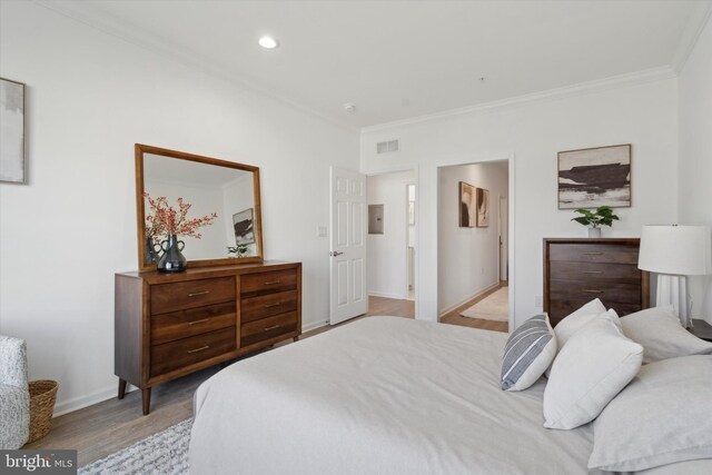 bedroom with light wood-type flooring and ornamental molding