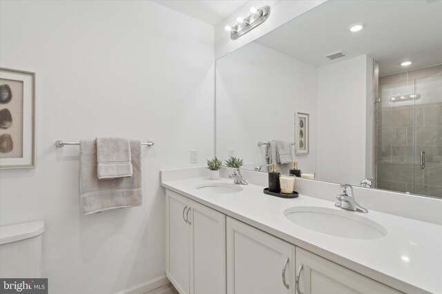 bathroom with walk in shower, vanity, and toilet