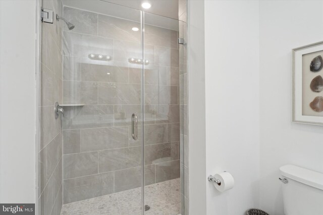 bathroom with toilet and an enclosed shower