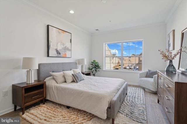 bedroom with ornamental molding and light wood-type flooring