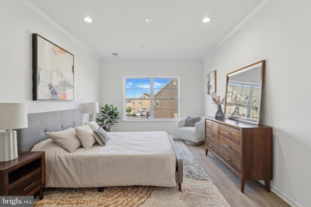 bedroom featuring light wood-type flooring and crown molding